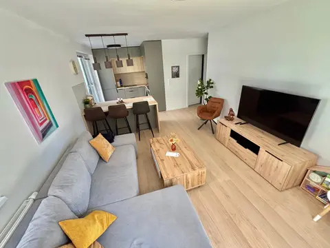 Obývacia izba s rohovou pohovkou a TV